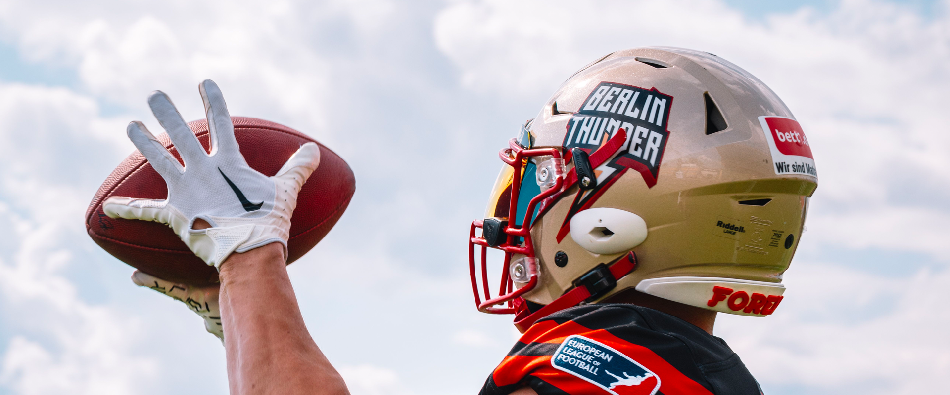 Photo : un joueur de football américain de Berlin thunders de profil tient le ballon entre ses mains gantées