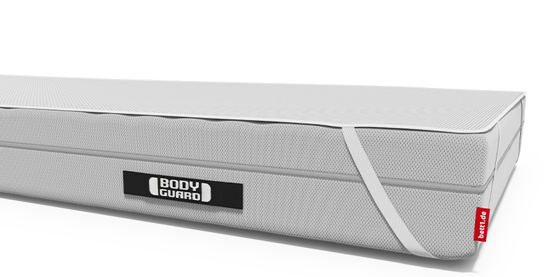 Matelas BODYGUARD® vu de côté avec sa housse blanche texturée, doté de poignées de transport intégrées et d’un logo BODYGUARD® visible sur la face latérale et recouvert d'une alèse BODYGUARD.