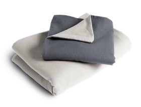Le linge de lit BODYGUARD® en flanelle plié : la housse de couette est pliée avec la face grise vers l'extérieur, la taie d'oreiller avec la face couleur anthracite.