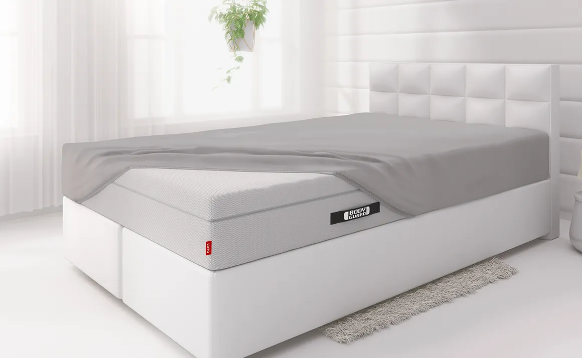 Lit avec un drap-housse BODYGUARD® recouvre une partie du matelas Boxspring BODYGUARD®. 