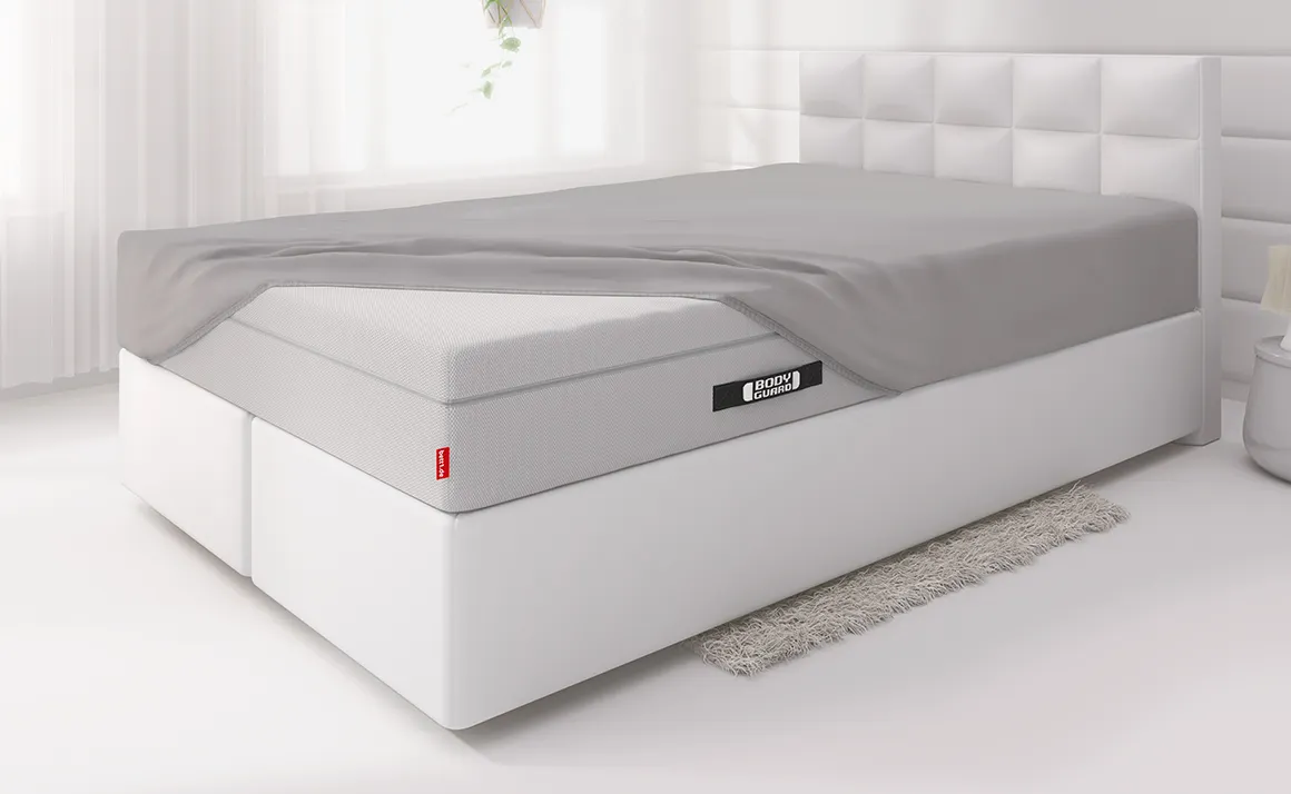 Lit avec un drap-housse BODYGUARD® recouvre une partie du matelas Boxspring BODYGUARD®. 