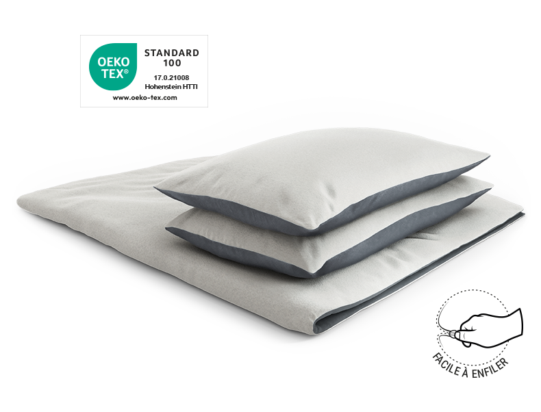 Les linge de lit en flanelle BODYGUARD® recouverts sur une couette pliée avec deux oreillers. Le label Oeko-Tex®. Illustration d'une main qui ferme une fermeture éclair. Texte : facile à enfiler
