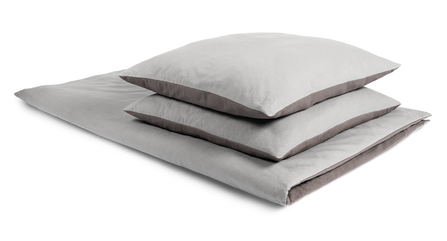 housse de couette en flanelle BODYGUARD pliée. Deux coussins carrés sont posés sur la housse de couette