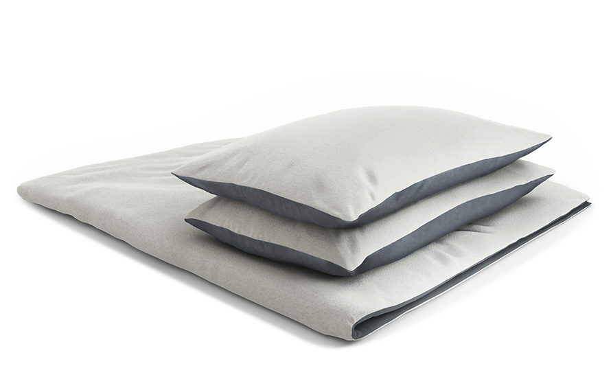 housse de couette en flanelle BODYGUARD pliée. Deux coussins carrés sont posés sur la housse de couette