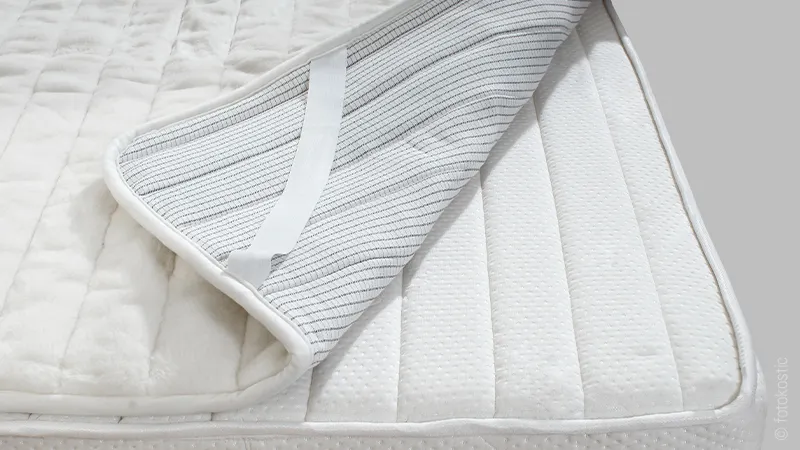 surmatelas repliée dans un coin avec élastiques de fxation