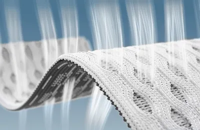 Gros plan sur un tissu technique blanc et noir, présentant une texture respirante et une structure aérée en forme de vague.