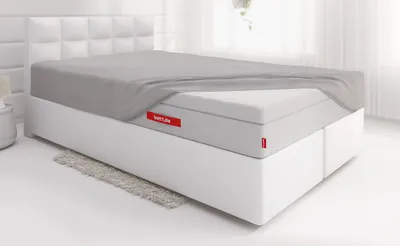 Lit avec un drap-housse BODYGUARD® recouvre une partie du matelas FLIP®. 